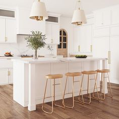 three stools sit at the center of a kitchen island