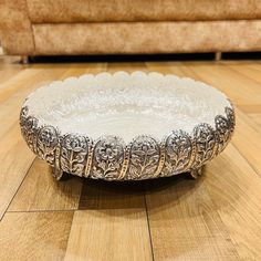 a silver plate sitting on top of a wooden floor