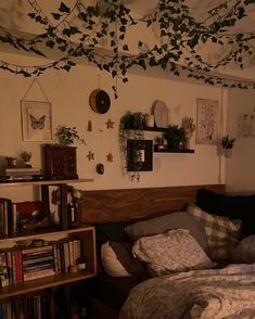 a bedroom with bookshelves and plants on the wall above the bed, along with other decor