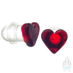 two heart shaped glass plugs sitting next to each other