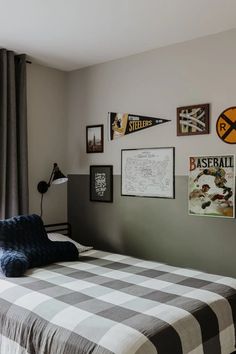 a bed sitting next to a window with pictures on the wall above it in a bedroom