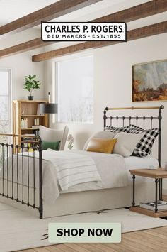 a bed room with a neatly made bed next to a window and wooden flooring