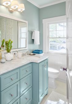 a bathroom with blue cabinets and white fixtures