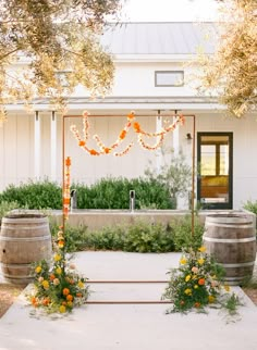 an outdoor ceremony setup with flowers and candles on the steps leading up to the entrance