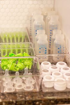 there are many plastic containers with toothbrushes and bottles on the counter top in front of them