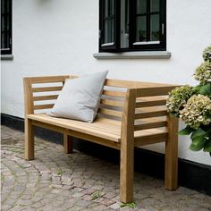 a wooden bench sitting in front of a white building