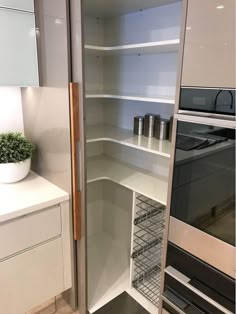 an empty kitchen with white cabinets and shelves