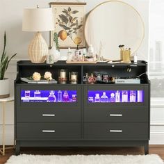 a black cabinet with blue lights on it in front of a mirror and potted plant