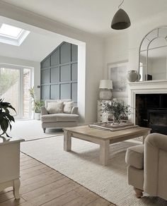 a living room filled with furniture and a fire place under a skylight in front of a window