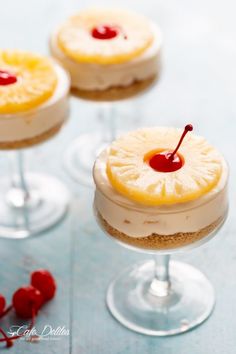 three small desserts with cherries on the top and one is topped with pineapple