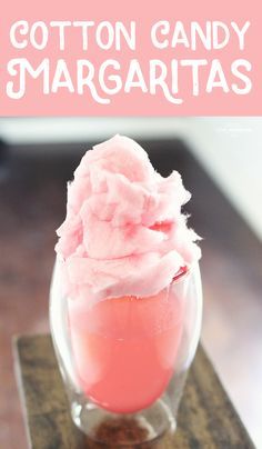 there is a pink ice cream in a glass on top of a wooden stand with the words cotton candy margaritas above it