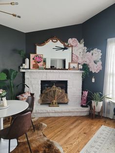 a living room filled with furniture and a fire place in front of a mirror on the wall