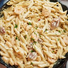 a skillet filled with pasta and shrimp