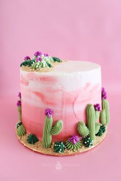 a cake decorated with pink and green frosting, cacti and succulents