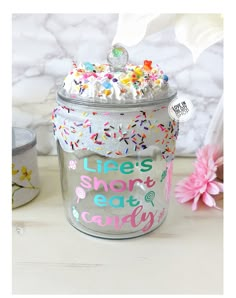 there is a cupcake in a tin with sprinkles on it and the words life's short eat candy