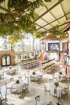 an indoor venue with tables and chairs set up for a formal function in the sun