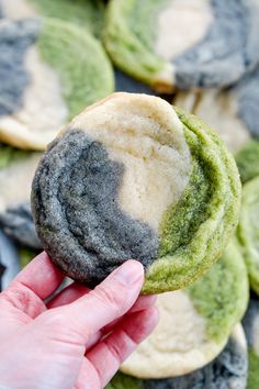 a hand holding up a green and white cookie