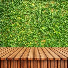 an empty wooden table in front of a green wall