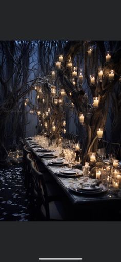 a long table is set with candles and place settings for an outdoor dinner in the woods