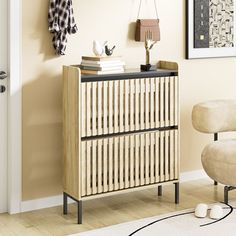 a wooden cabinet with two drawers and a lamp on top in a room next to a chair