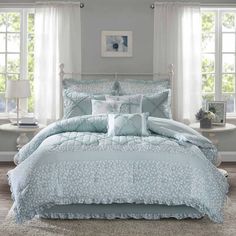 a bed with blue comforters and pillows in a room