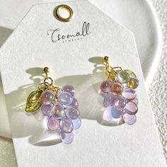 Refresh your warm weather style with these vibrant Czech glass grape earrings. Handcrafted by artisans, each earring features lush purple glass beads mimicking ripe, juicy grapes. Crystal studs add a touch of sparkle, while the leverback closures keep the lightweight earrings securely in place. Doesn't the Bohemian style impart fresh charm? Vibrant yet versatile, these handmade grape earrings add a pop of color and artistry to casual and dressy summer outfits alike. Their creativity makes them a Grape Earrings, Funky Jewelry, Jewelry Lookbook, Fantasy Jewelry, Dream Jewelry, Glass Earrings, Summer Jewelry, Pretty Jewellery, Ear Jewelry