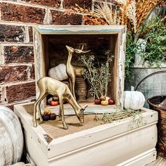 a deer figurine sitting on top of a wooden box next to pumpkins