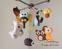 an assortment of stuffed animals hanging from a metal rod in a nursery or child's room