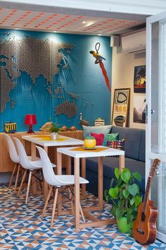 a living room filled with furniture next to a blue wall covered in pictures and artwork