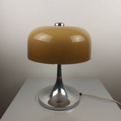 a lamp that is sitting on top of a white tablecloth with a cord attached to it