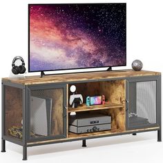 a flat screen tv sitting on top of a wooden entertainment center with metal mesh doors