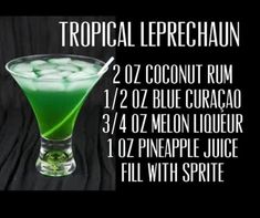 a green cocktail in a tall glass with limes on the rim and labeled tropical leprechaun