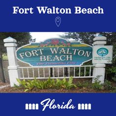 the sign for fort walton beach is shown in front of some bushes and trees,