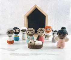 small crocheted dolls sitting in front of a blackboard