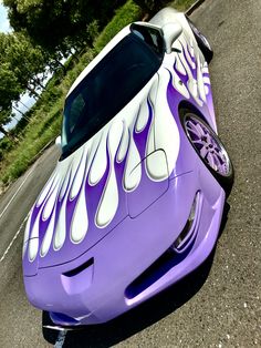 a purple and white car with flames painted on it