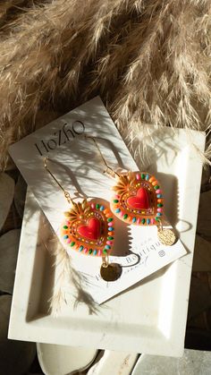 a pair of earrings sitting on top of a white tray next to some furnishing