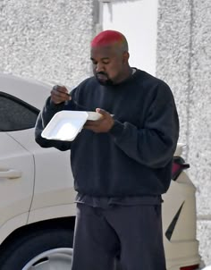 a man in sweatpants and a sweatshirt is holding a tray