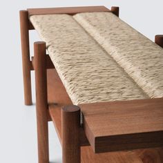 a wooden bench with woven seat cushion