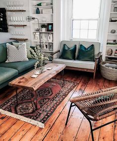 a living room filled with lots of furniture and decor on top of hard wood floors