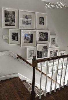 there are many pictures hanging on the wall next to the bannister and stairs