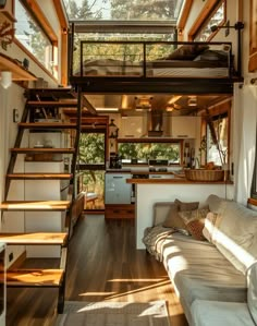 a living room filled with furniture next to a kitchen and loft style bed on top of a wooden floor