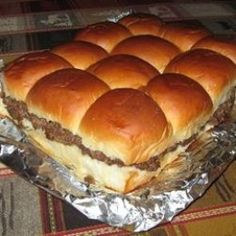 a large cheeseburger sitting on top of a pan covered in aluminum foil, ready to be served