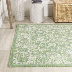 a green rug in the corner of a room with wicker baskets on the floor