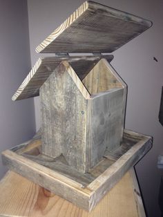 an open wooden box sitting on top of a table next to a birdhouse and other items