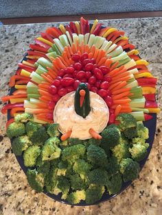 a turkey made out of veggies on a plate with carrots and broccoli