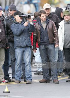 a group of people standing on the side of a road next to each other with cameras