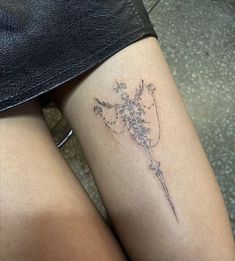 a woman's leg with a flower tattoo on her left thigh and the bottom half of her legs