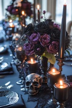 a table topped with lots of purple flowers and candles next to a skull head on top of a black table cloth