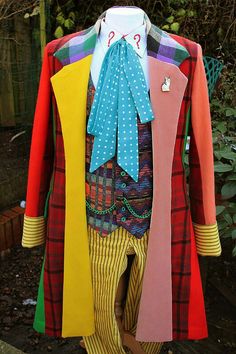 a colorful coat and pants are hanging on a clothes hanger in the yard outside