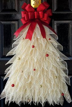 a christmas tree made out of burlocks and red bows on the front door